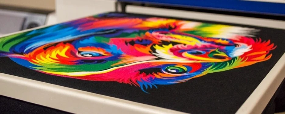 Direct-to-garment print being laid down on a dark garment