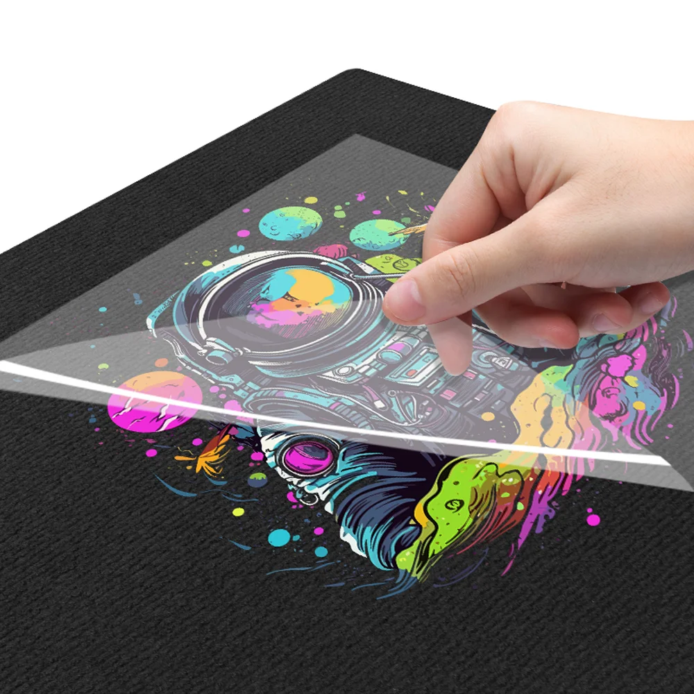 A printed DTF transfer film being peeled away from a garment